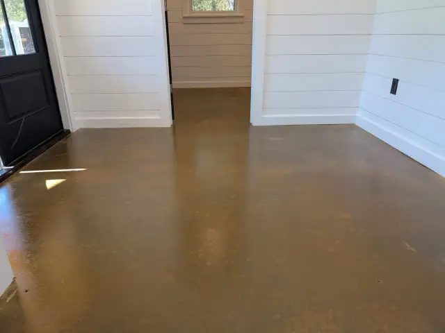 High-gloss stained concrete in a white shiplap entry