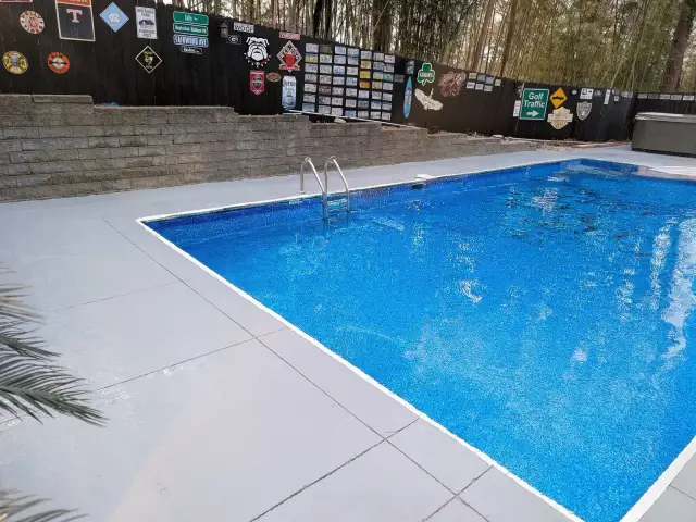 Coated pool deck around a bright blue pool