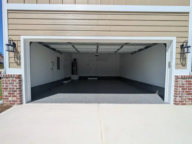 Two-car garage seen from the driveway, dark flake floor