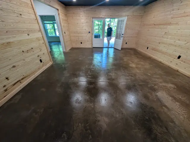 Glossy dark stained concrete in a wood-walled room