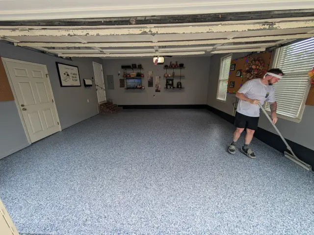 Crew member spreading a garage floor coating
