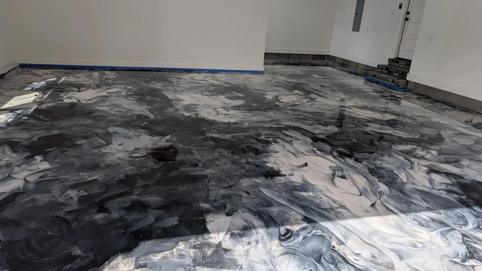 Black and silver metallic epoxy floor mid-installation