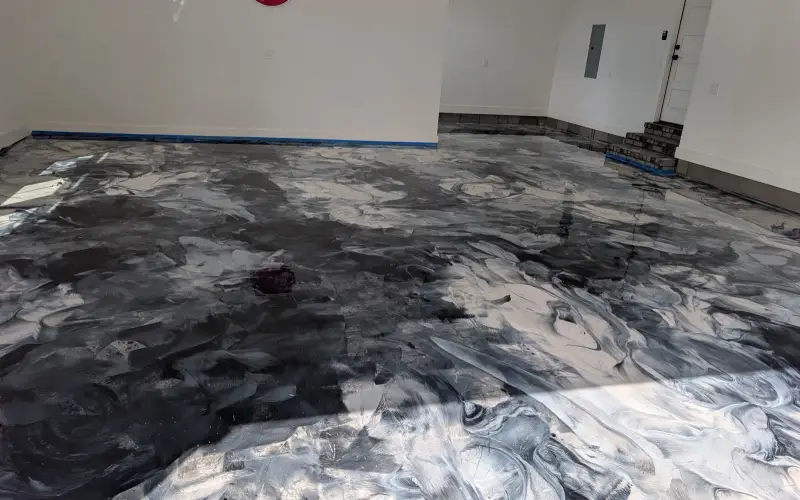 Black and silver metallic epoxy floor mid-installation