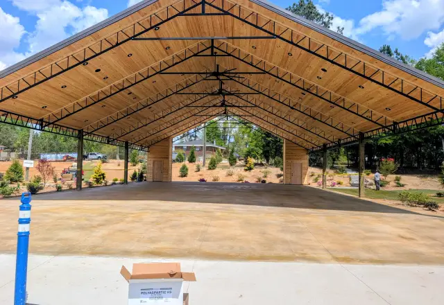 Warm-toned stained concrete floor beneath an open timber pavilion